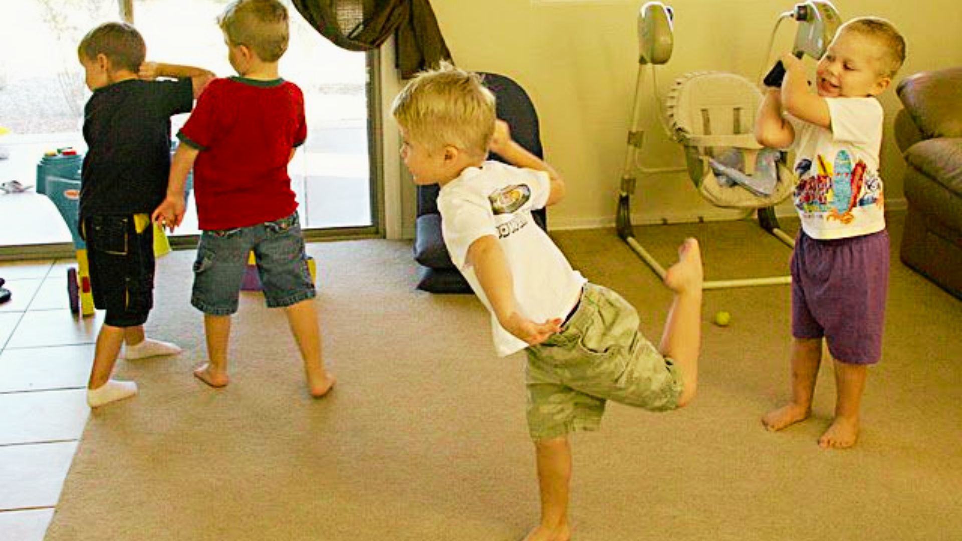 A group of young children joyfully playing freezing dance together in a cozy living room filled with toys and colorful furniture.