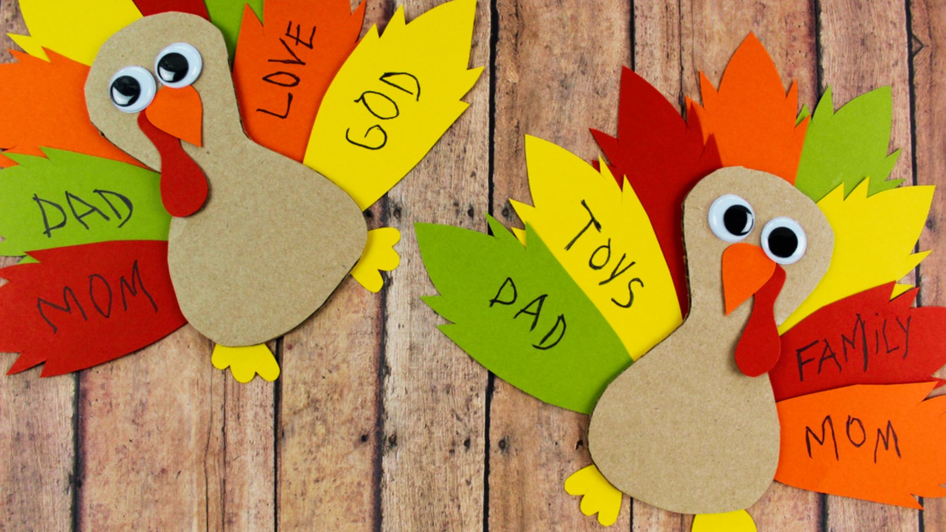 Two paper turkey crafts displaying the words "dad," "mom," and "dad mom" in colorful letters on a festive background.