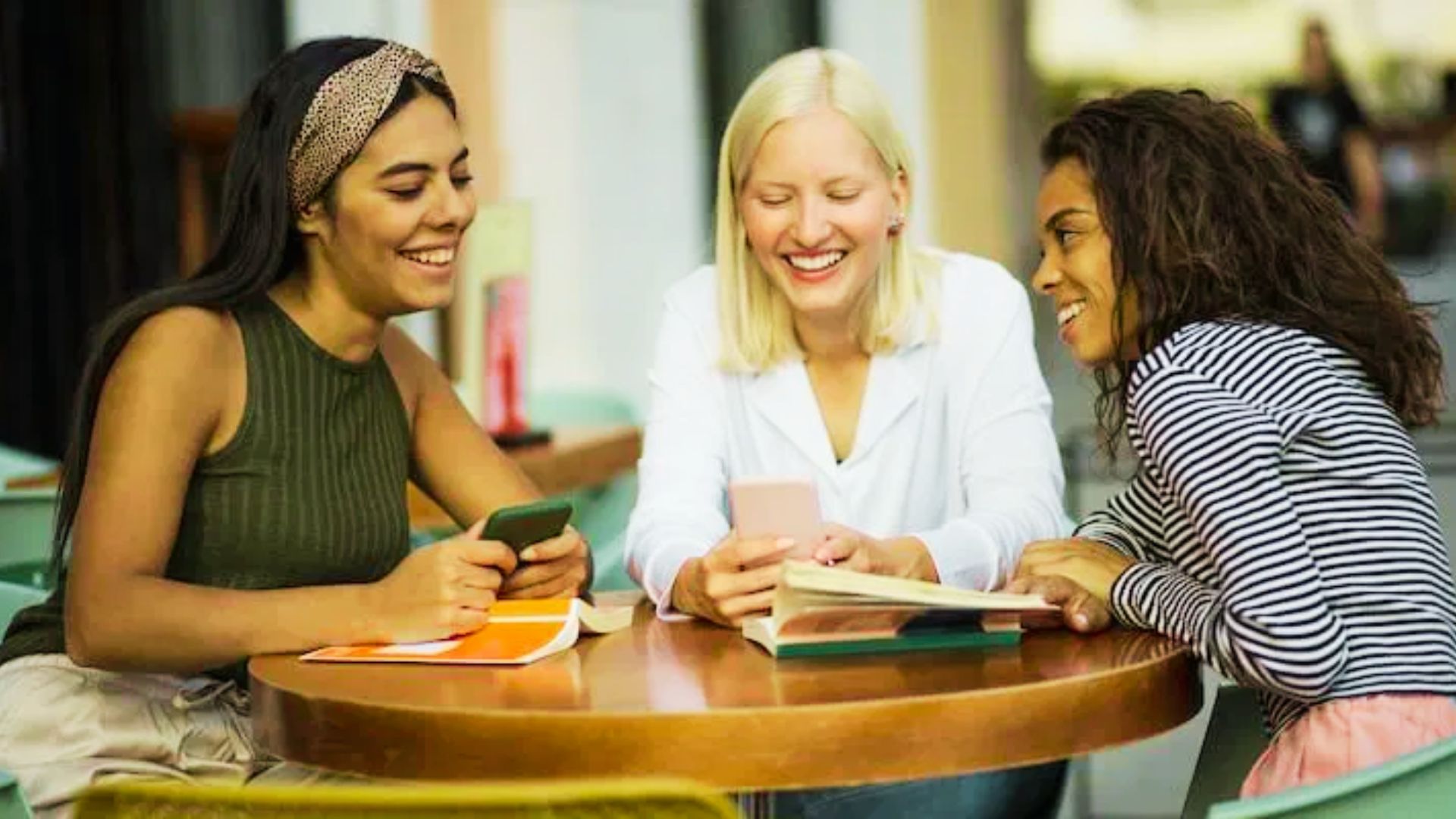 Three young women engaged in discussion at a table.