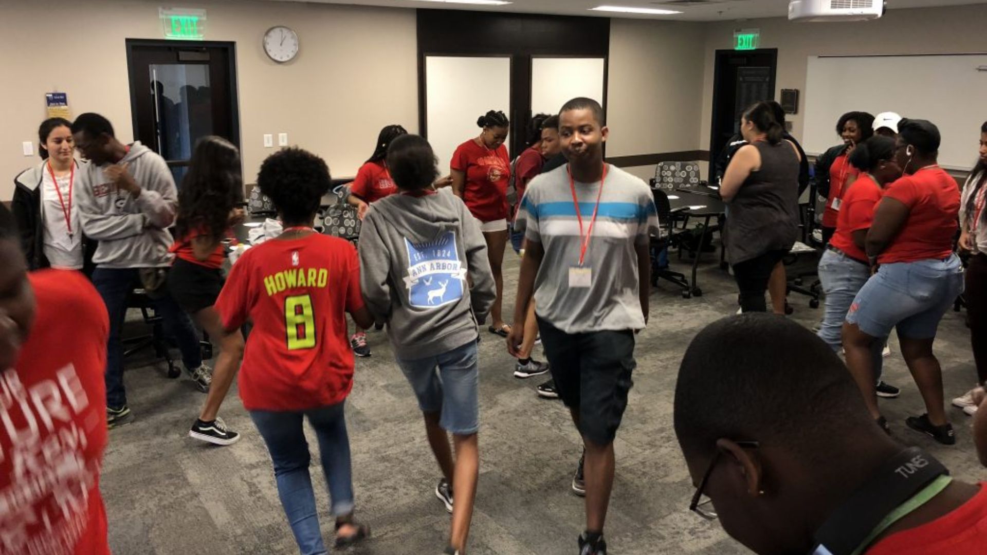 Students engaged in a group activity at school, moving around a classroom and working together during an icebreaker game.