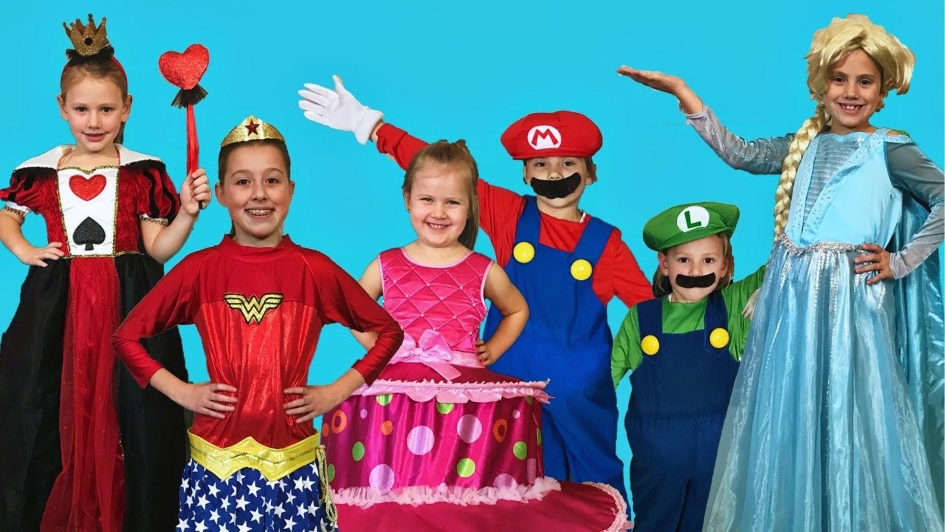 Children in colorful costumes like Wonder Woman, Mario, Elsa pose, blue background.
