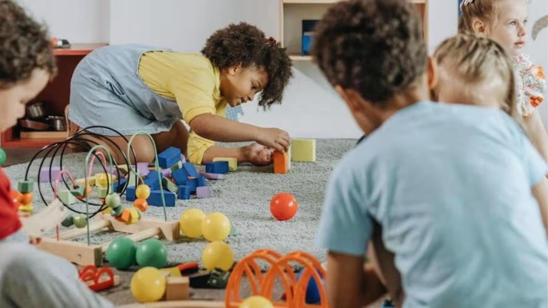 Kids play with blocks balls beads on carpet together