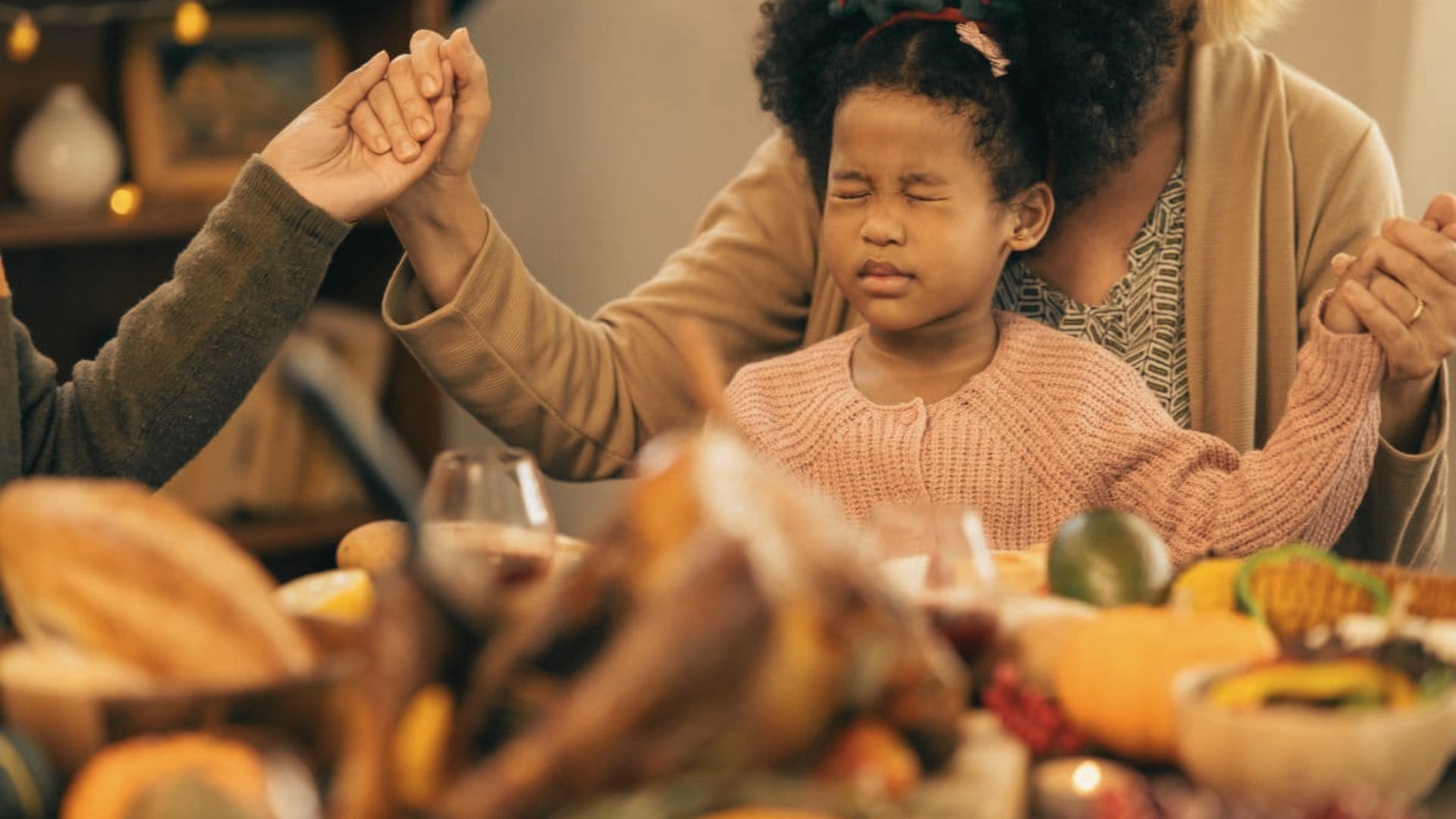 A family gathered around a table, joyfully celebrating Thanksgiving with a festive meal and warm smiles.