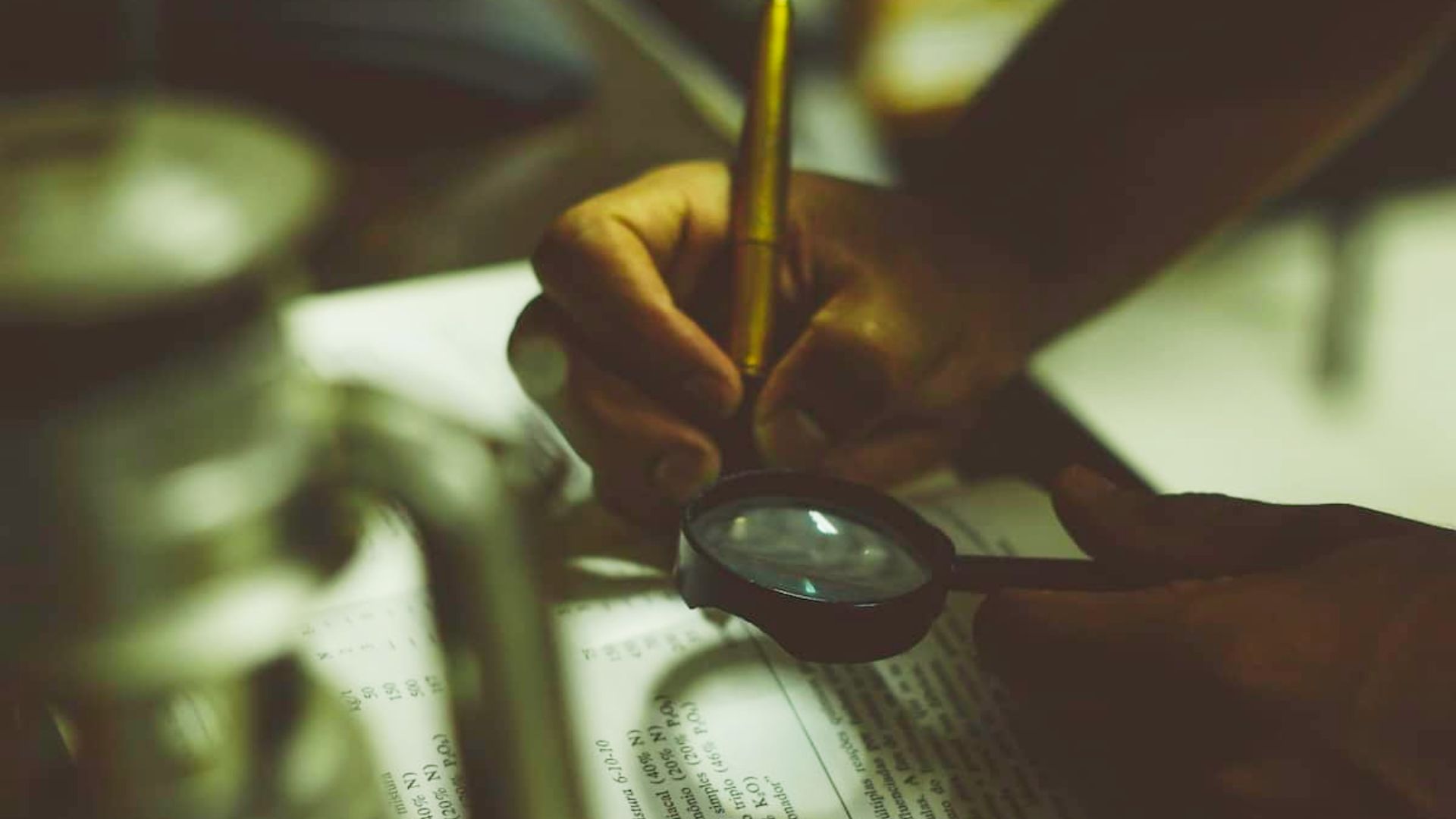 A person examines a piece of paper with a magnifying glass, focusing on details related to problem-solving activities for teens.