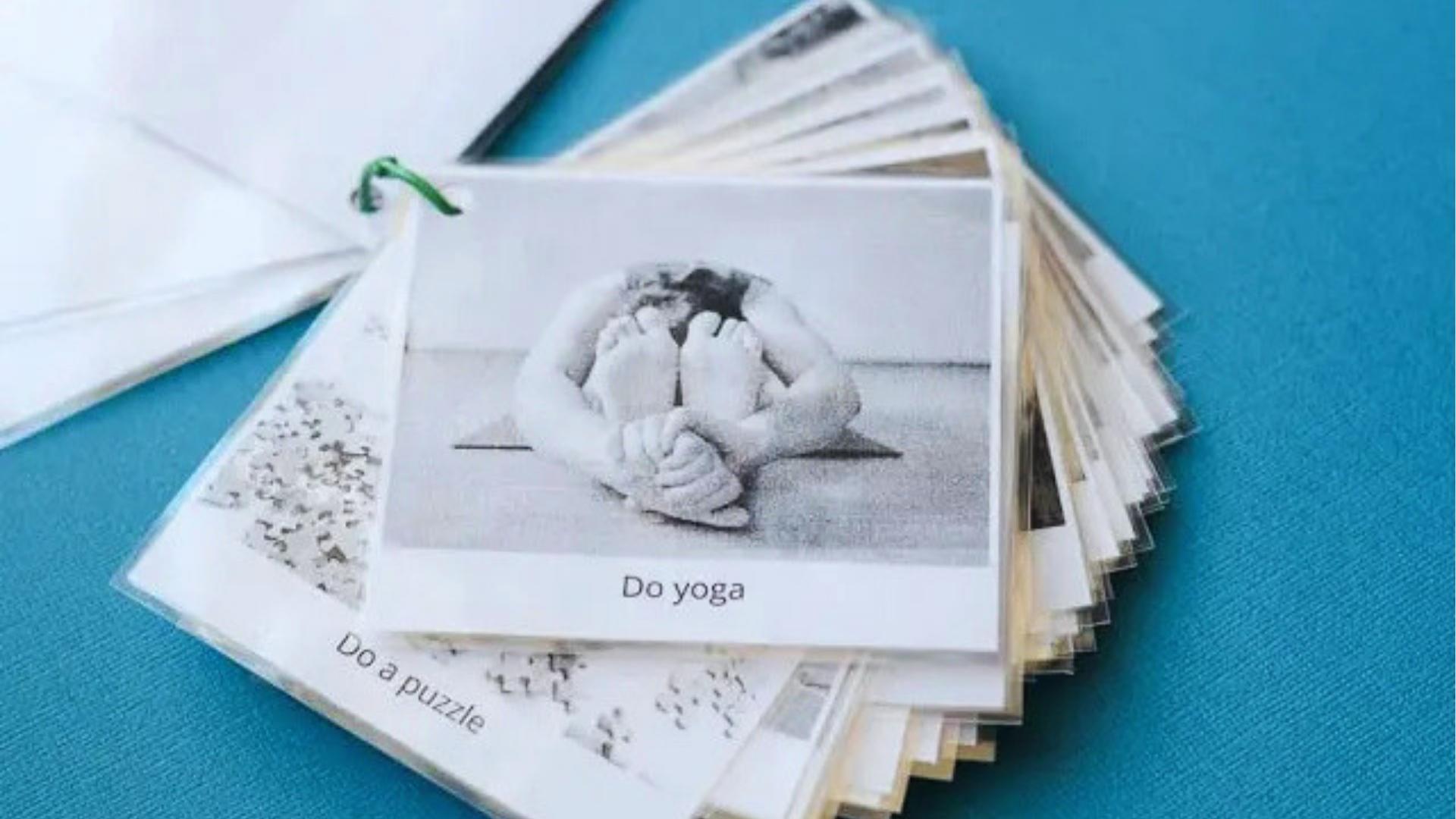 Laminated visual activity cards on ring, top card shows Do yoga, calm prompts, Activities for Autistic Kids.