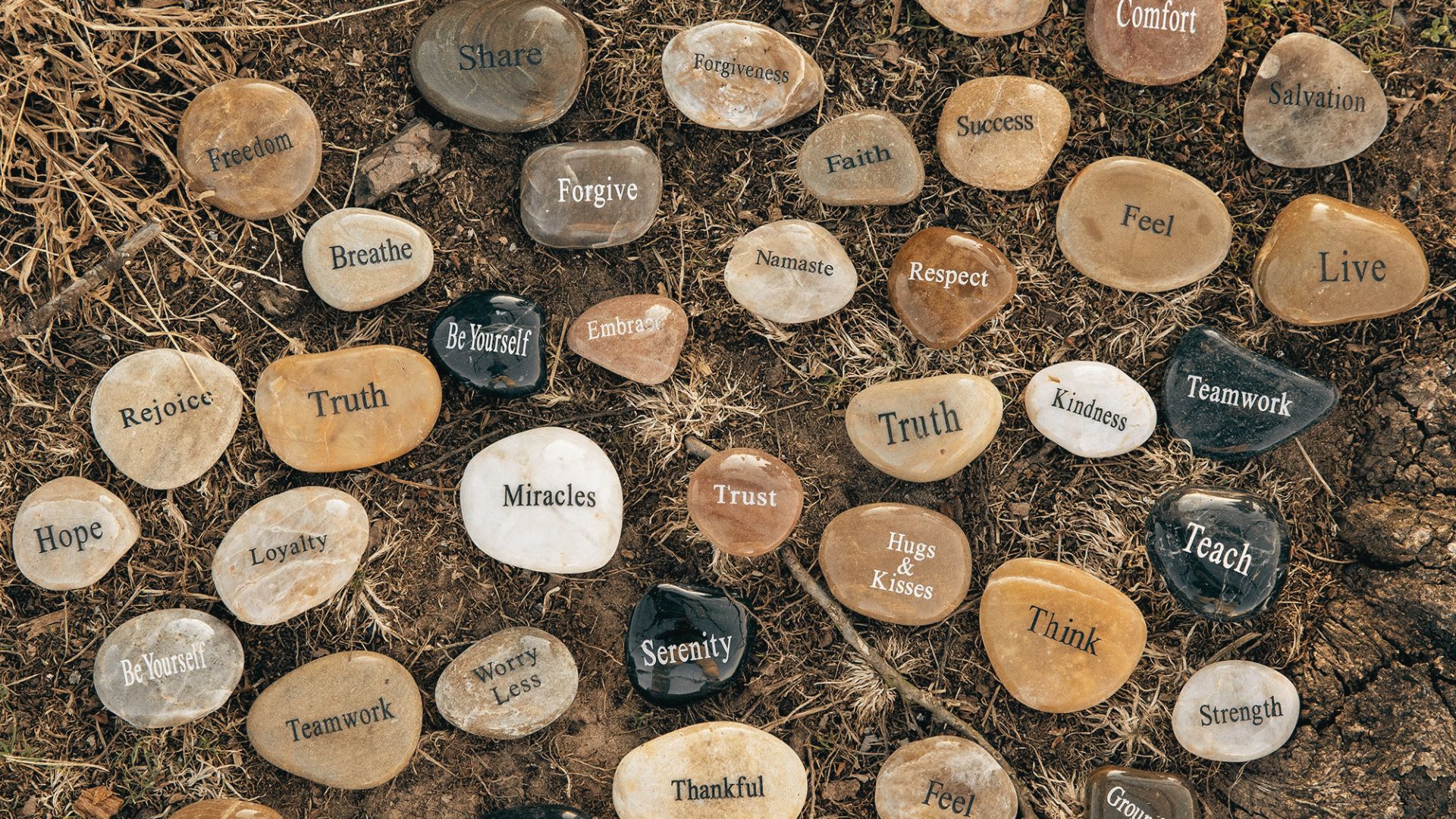 A collection of rocks stacked together, each labeled with many emotions, representing individual identities or memories.