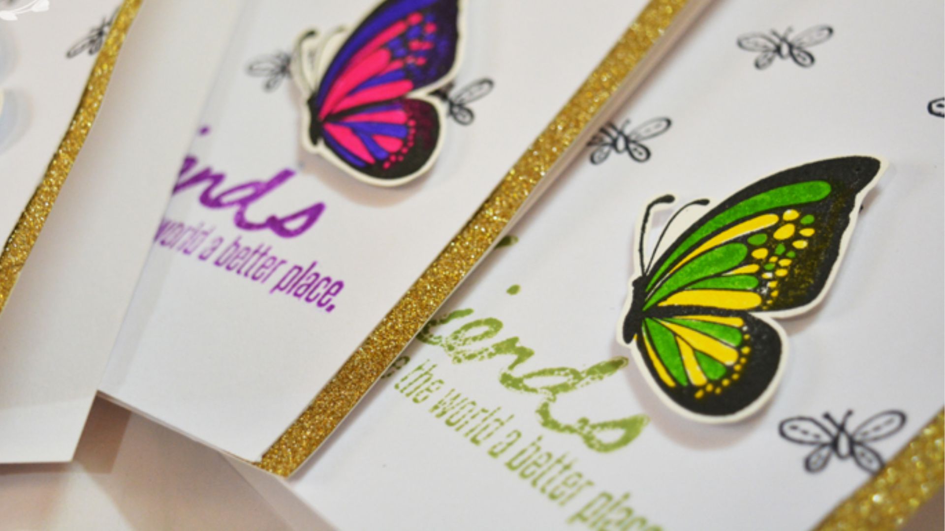 Close-up of handmade friendship cards decorated with colorful butterflies and text that reads friends make the world a better place, a craft activity for preschoolers to express appreciation