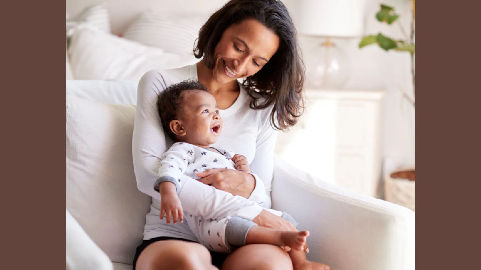 Mother uses a supported lap hold while seated. Baby sits securely on her lap with one arm across the chest and a hand under the bottom.