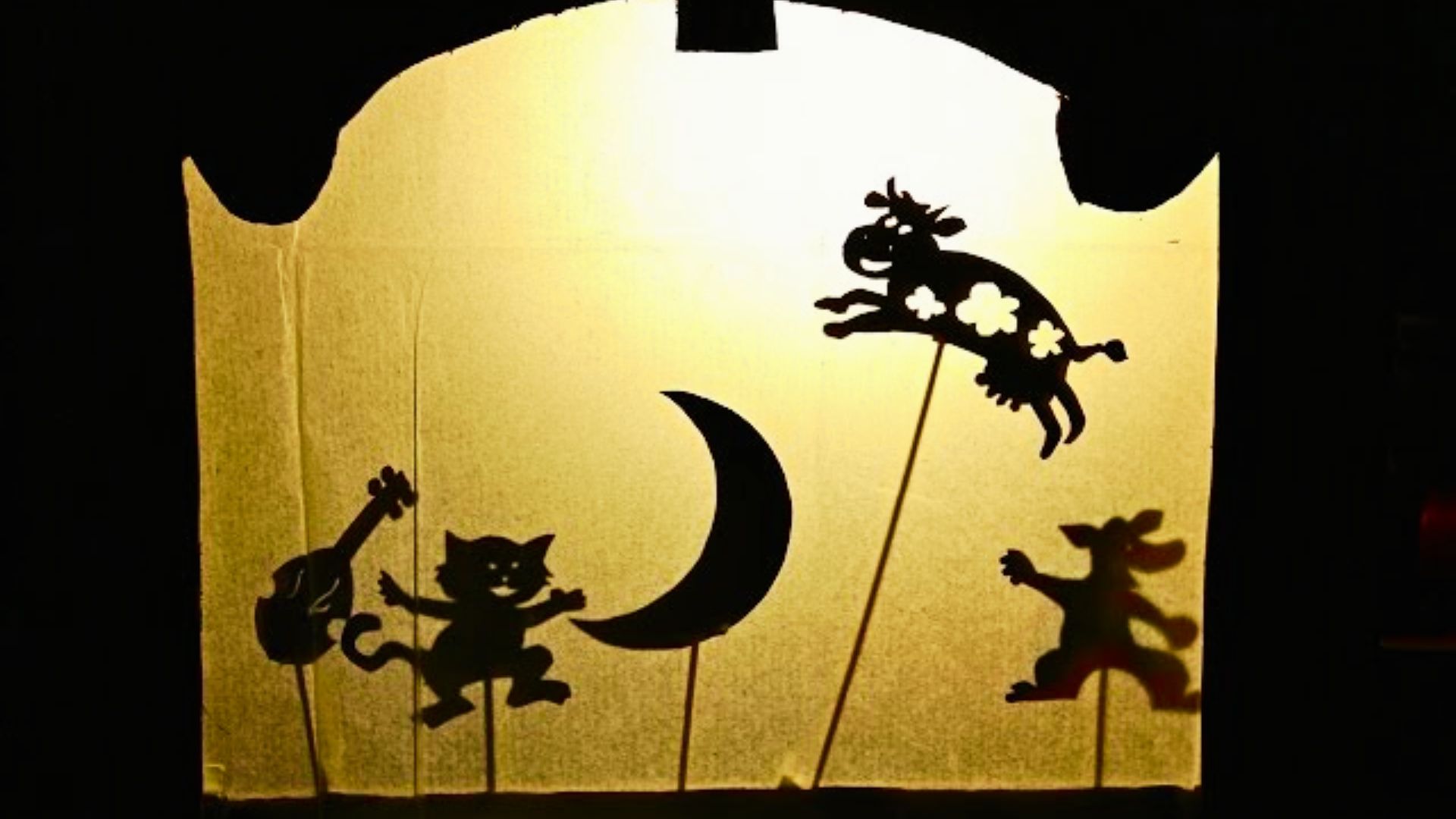 A shadow of a cat and a dog playfully projected on a window, creating a whimsical silhouette scene.