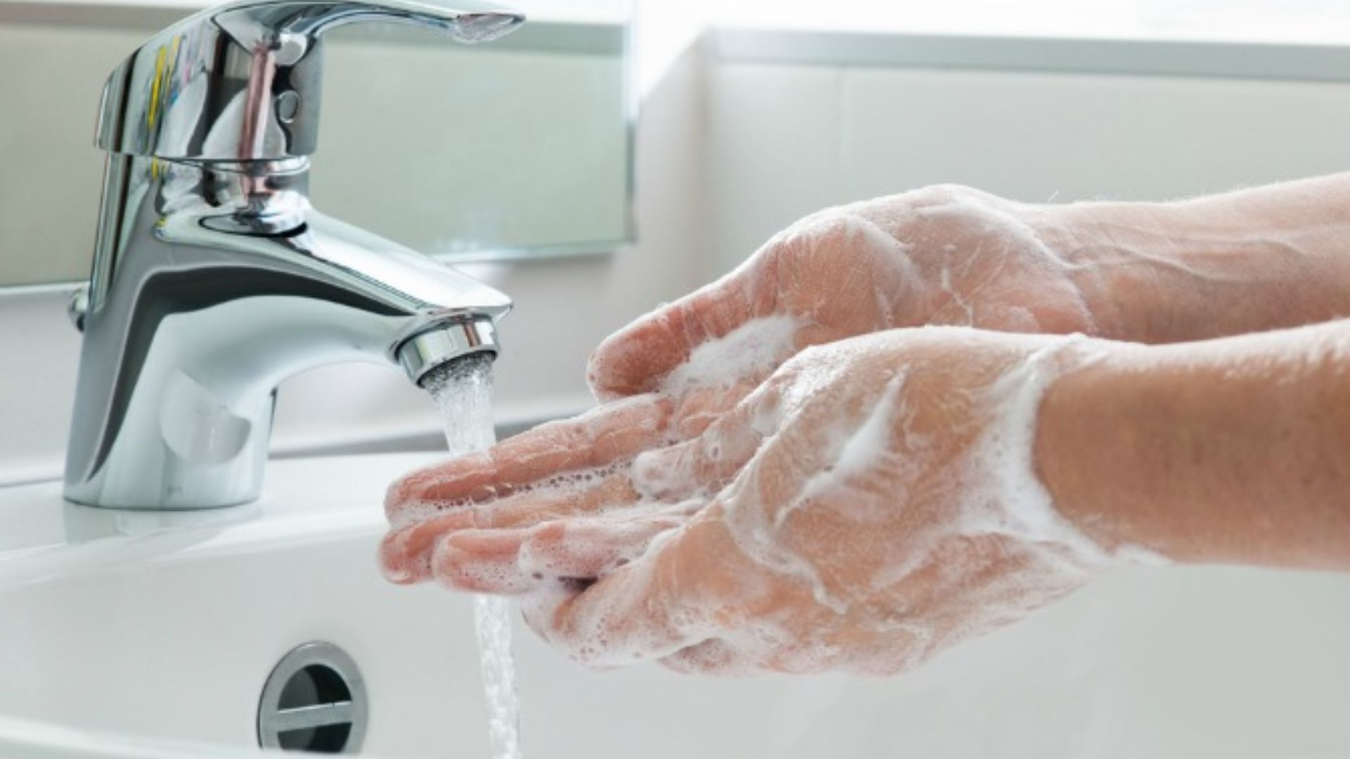 Step of holding a baby correctly: Wash hands thoroughly with soap and running water before picking up a newborn to prevent germs.