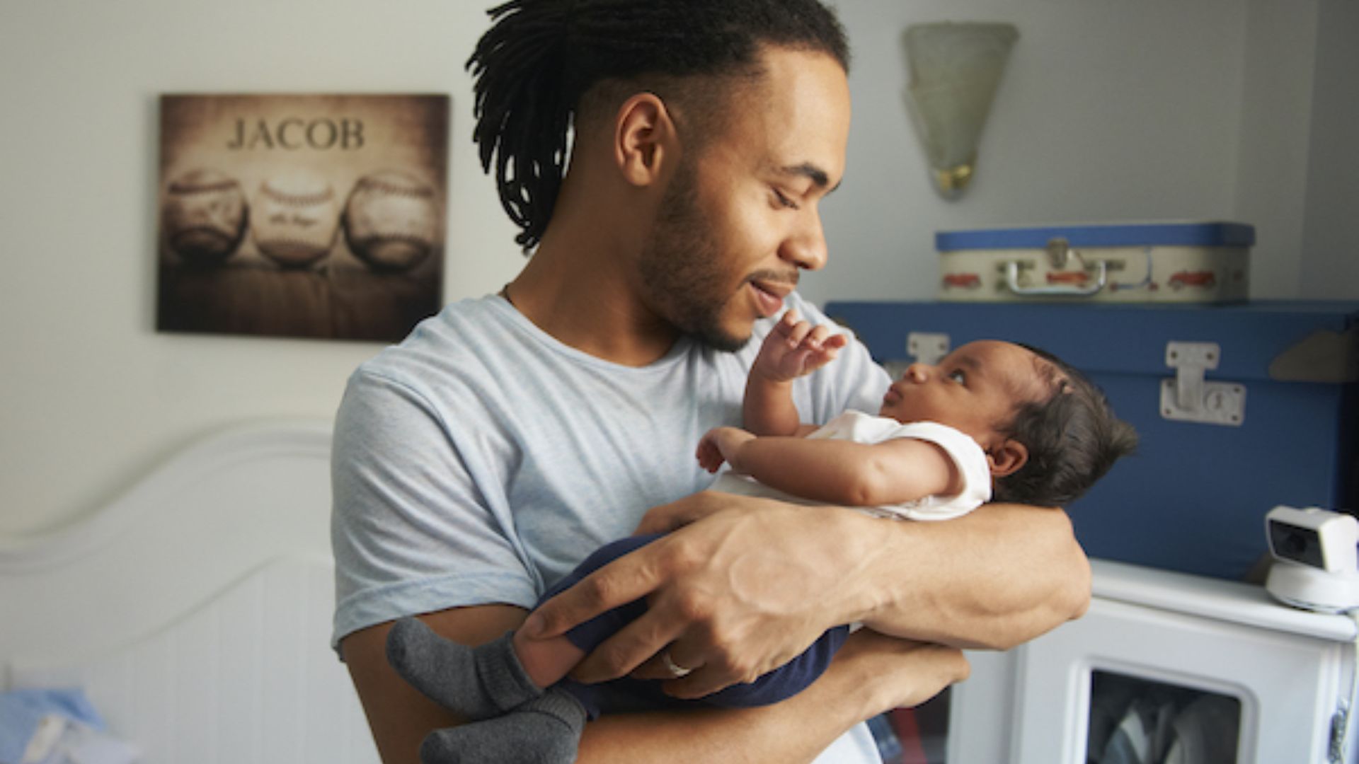 Father demonstrating the cradle hold: Baby's head is supported in the crook of the arm while the other hand supports the baby's bottom and back.