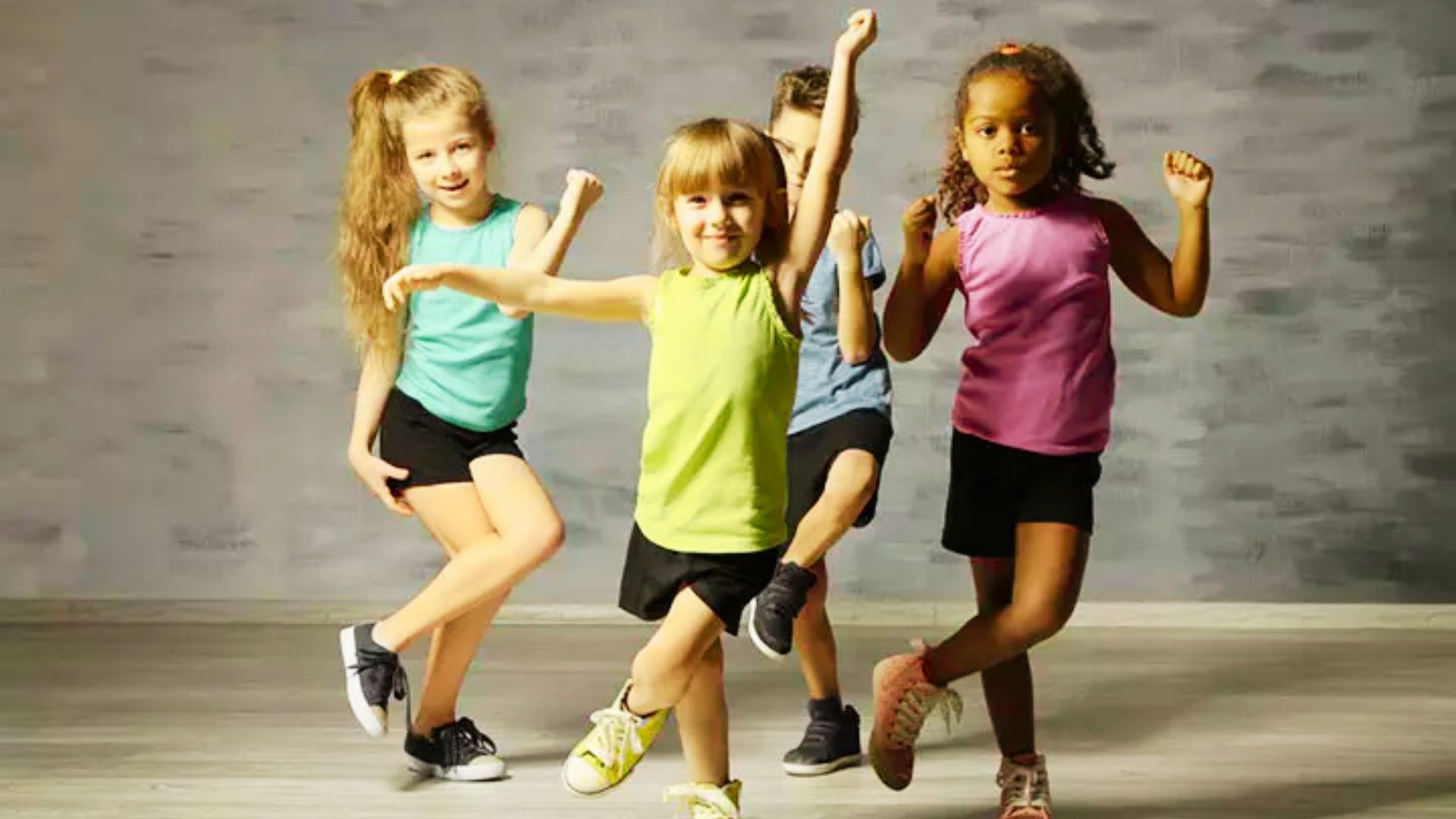 Children joyfully dance together in a bright studio, showcasing their enthusiasm and energy.