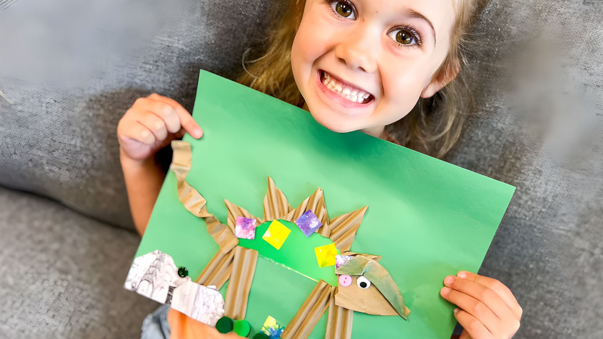 A girl displays a paper plate decorated with a dinosaur, engaging in fun dinosaur activities for preschoolers.