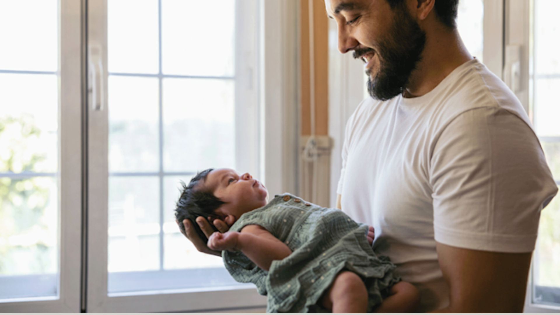Newborn is nestled in arms with head supported by the forearm and hand, keeping the baby's body aligned and secure.