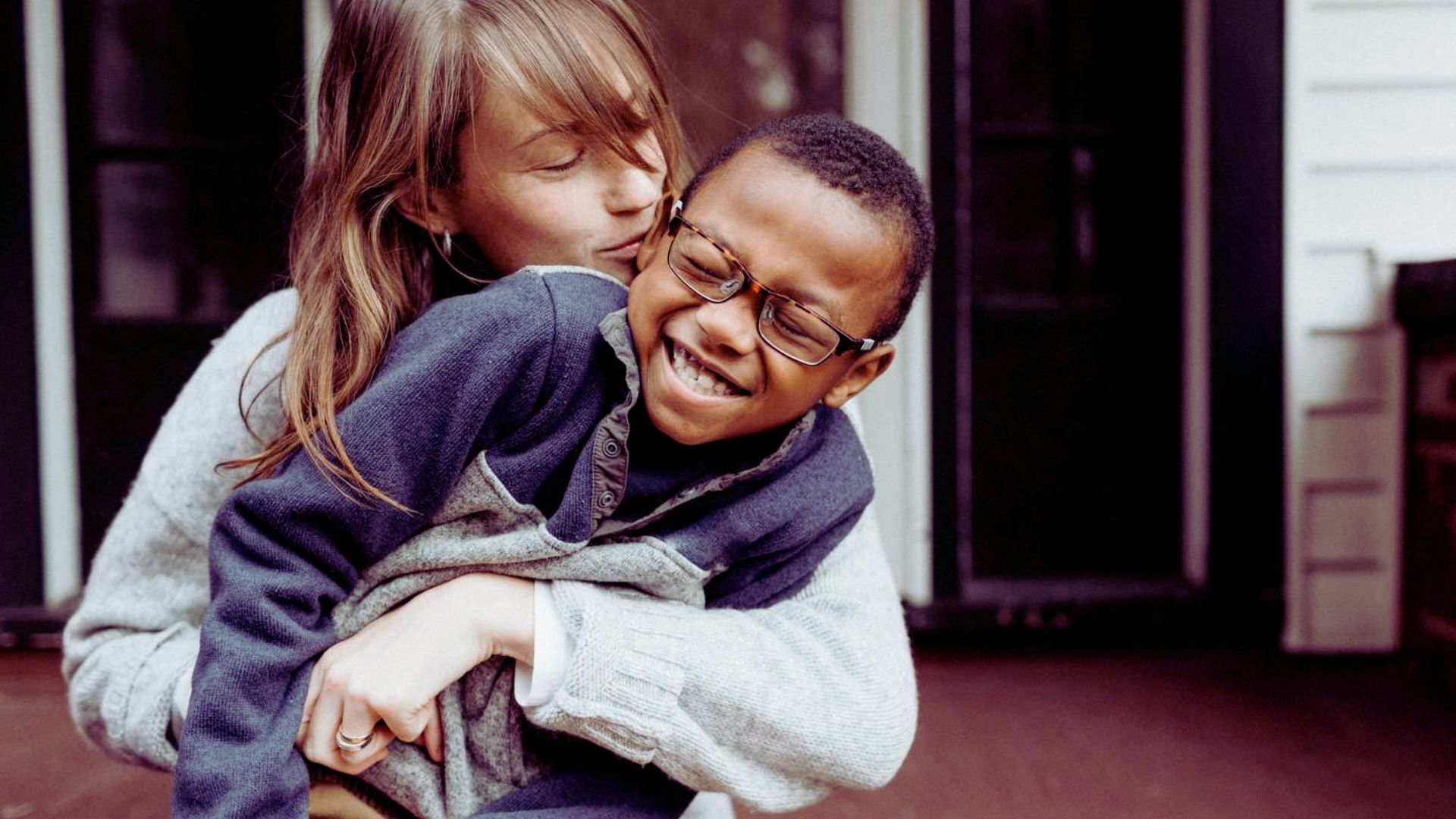 A young boy hugs a woman tightly, capturing a heartfelt moment of connection.