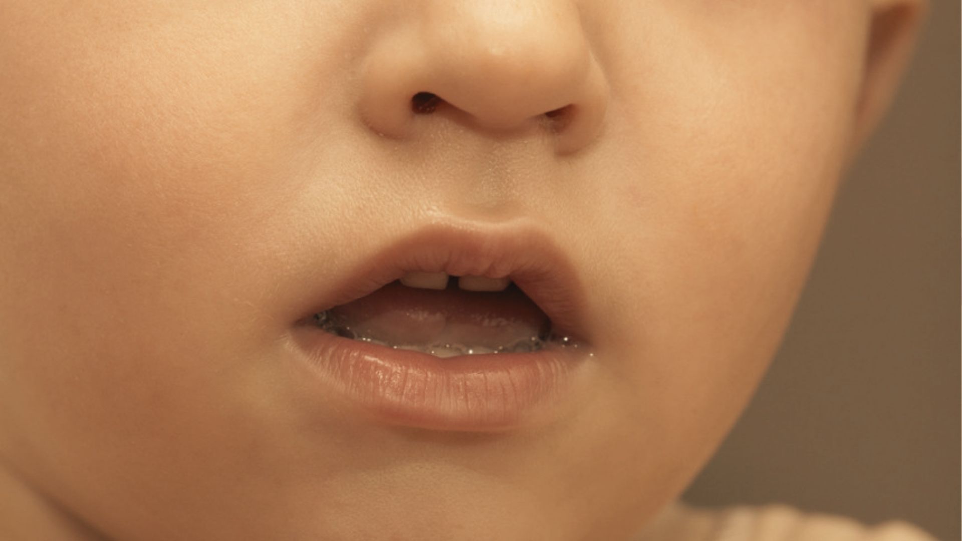 Close-up of a baby’s open mouth showing a small gap between the two upper front teeth.